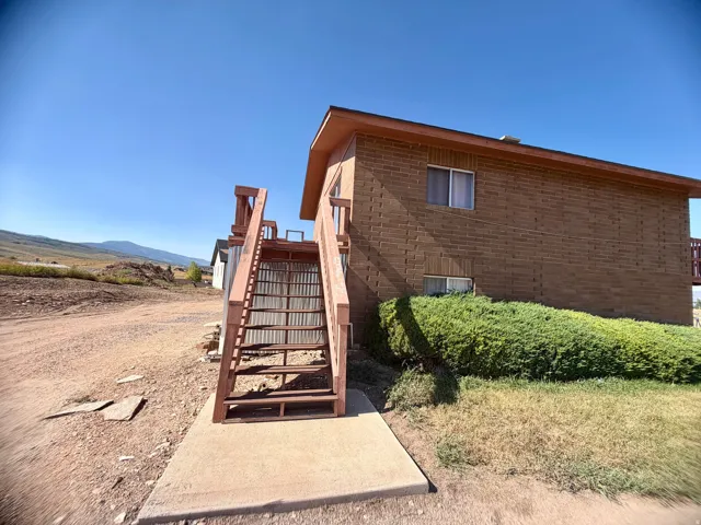 Brick exterior with metal entry gate and concrete landing