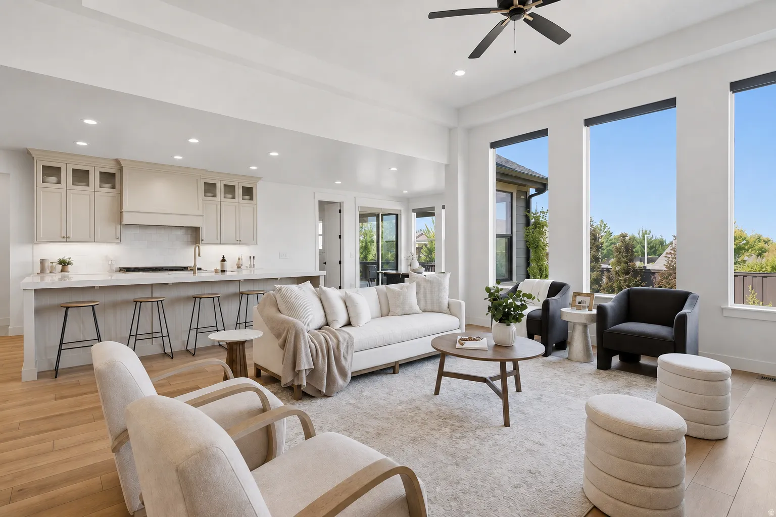 Spacious open-concept living area with high ceilings and wood-finish flooring