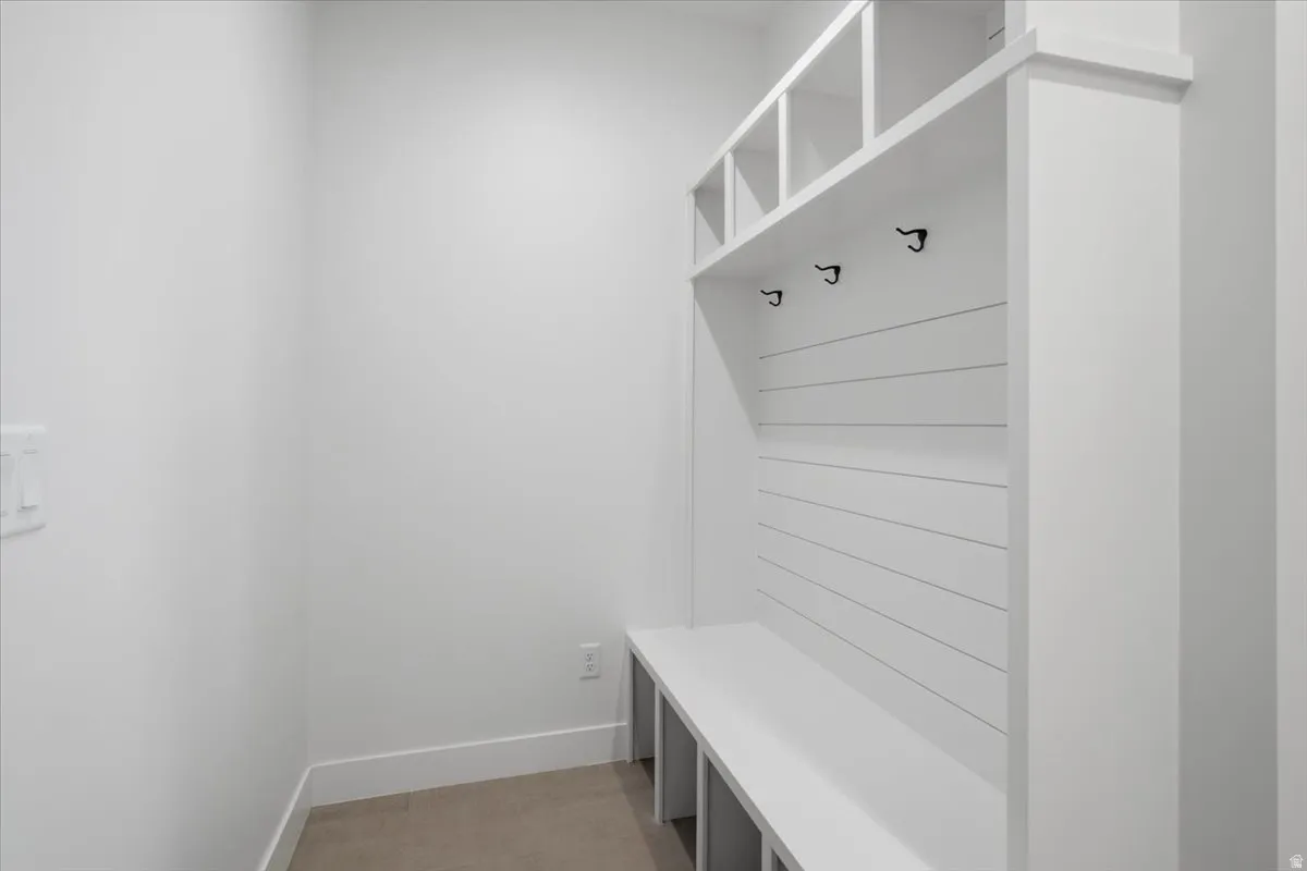 Built-in storage bench with overhead cubbies, shiplap backing, and matte black hooks