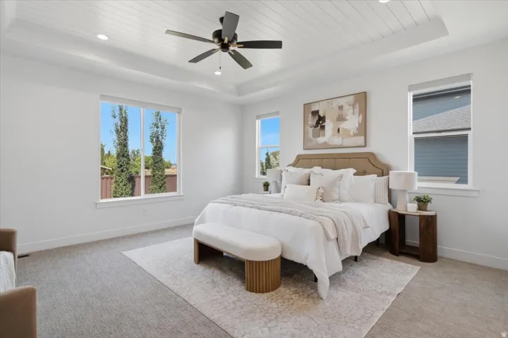 Tray ceiling with shiplap-style detailing, recessed lighting, and ceiling fan