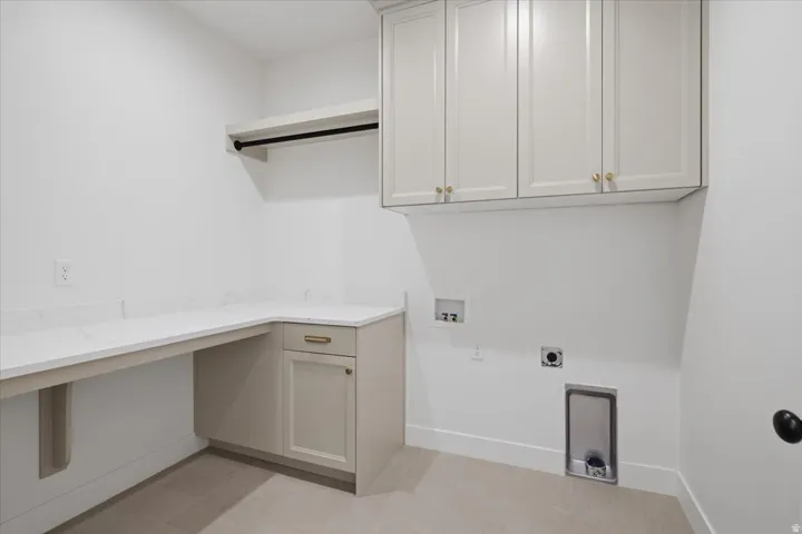Built-in cabinetry with gold-tone hardware, white countertops, and a wall-mounted hanging rod