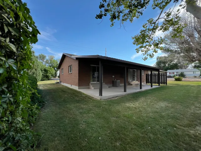 Brick exterior, covered patio, concrete patio, mature landscaping, sliding glass doors
