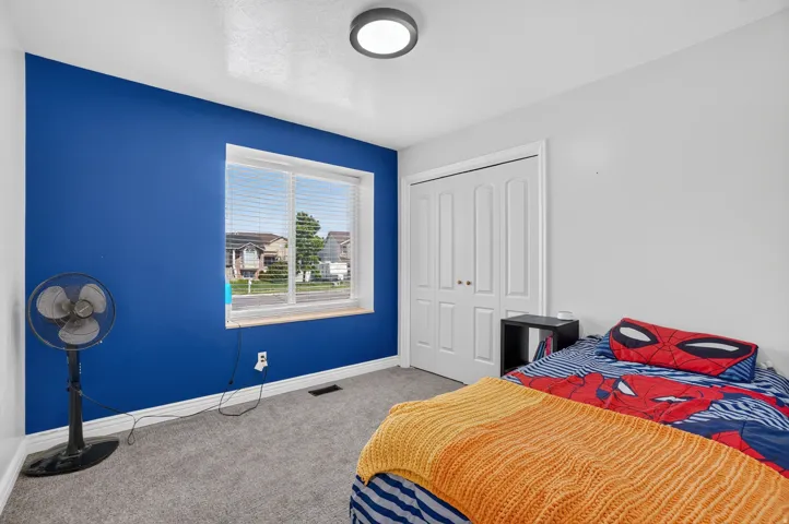 Expansive interior with a neutral color palette, grey carpeting, and a dual-panel closet door