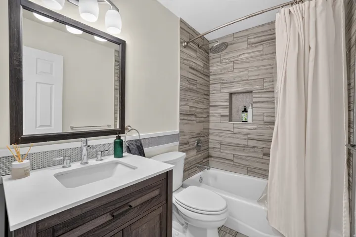 Bathroom featuring a vanity with a white countertop, chrome faucet, and a large framed mirror
