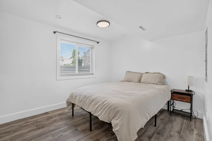 Recessed lighting, wood-finish flooring, white walls, and a window with blinds