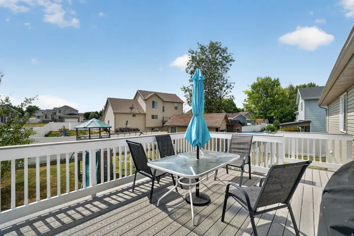 Expansive outdoor deck with white railing, composite decking, and a backyard gazebo