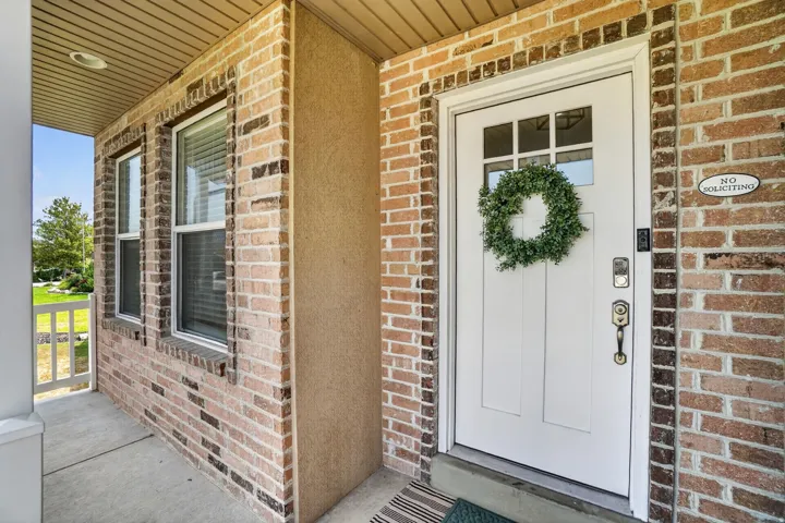 Brick exterior with stucco accents, an inviting covered front entry, transom window on the main door, and multiple windows