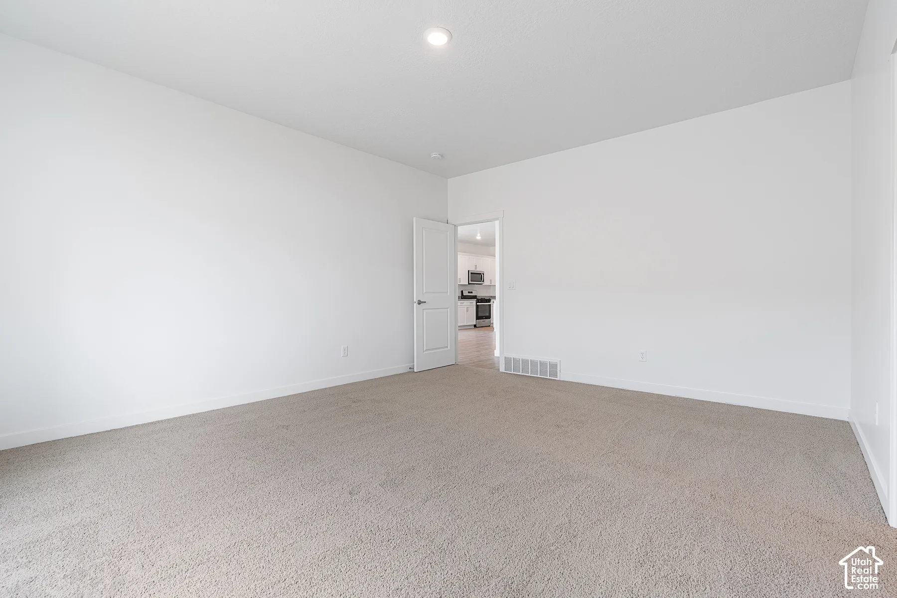 Spacious room with light-toned carpeting and neutral wall finishes