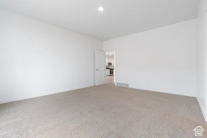 Spacious room with light-toned carpeting and neutral wall finishes