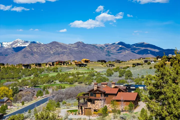 Custom mountain residence featuring a stone and wood exterior with a prominent balcony