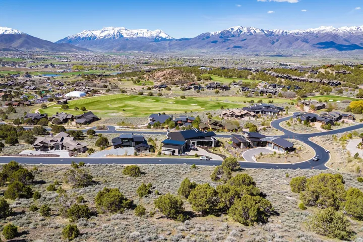 Expansive aerial view showcasing a residential development with custom homes and winding streets