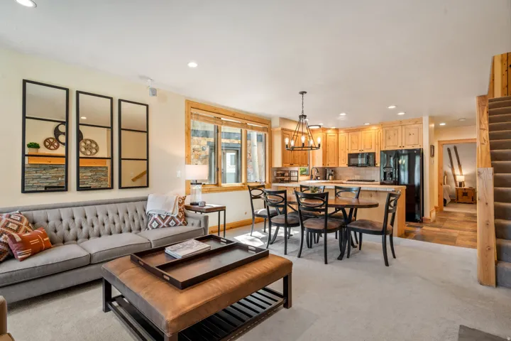 Open-concept living space featuring wood-finish cabinetry, black appliances, and a built-in kitchen island