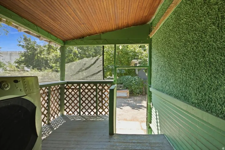 Screened porch with wood-finish ceiling planks, lattice railing, and painted wood flooring