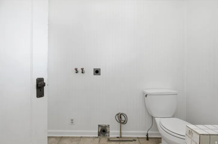 White paneled walls and a white toilet