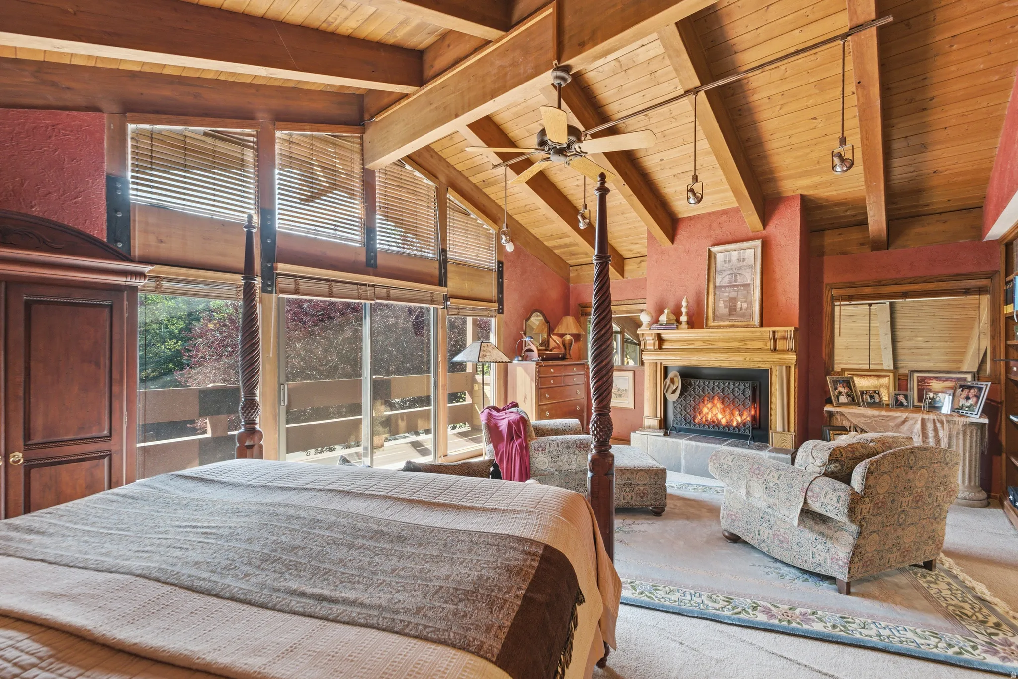 Primary bedroom suite featuring exposed wooden beam ceiling, wood-finish flooring, and a four-poster bed frame