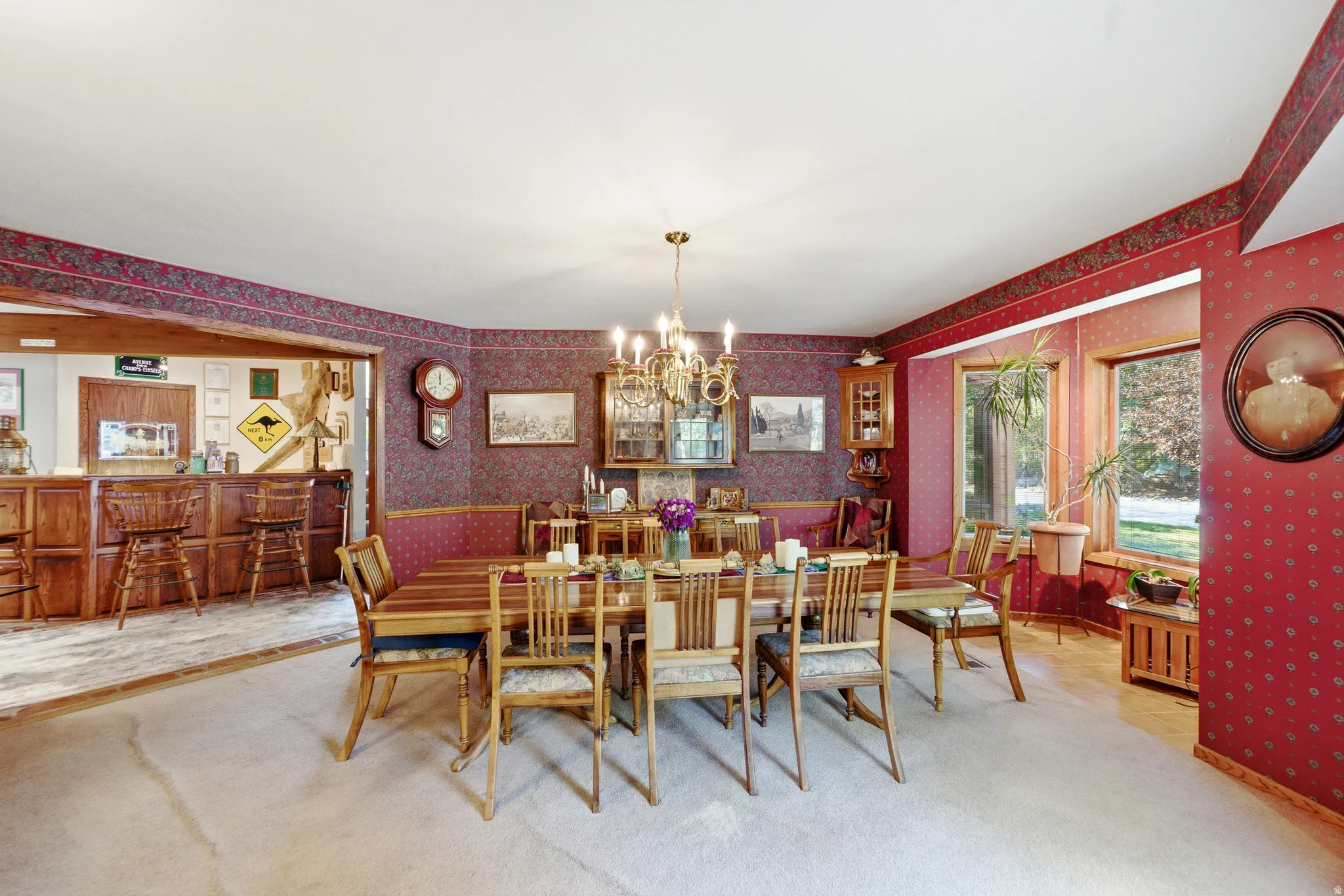 Dining area featuring a chandelier, large windows, and a built-in wooden bar