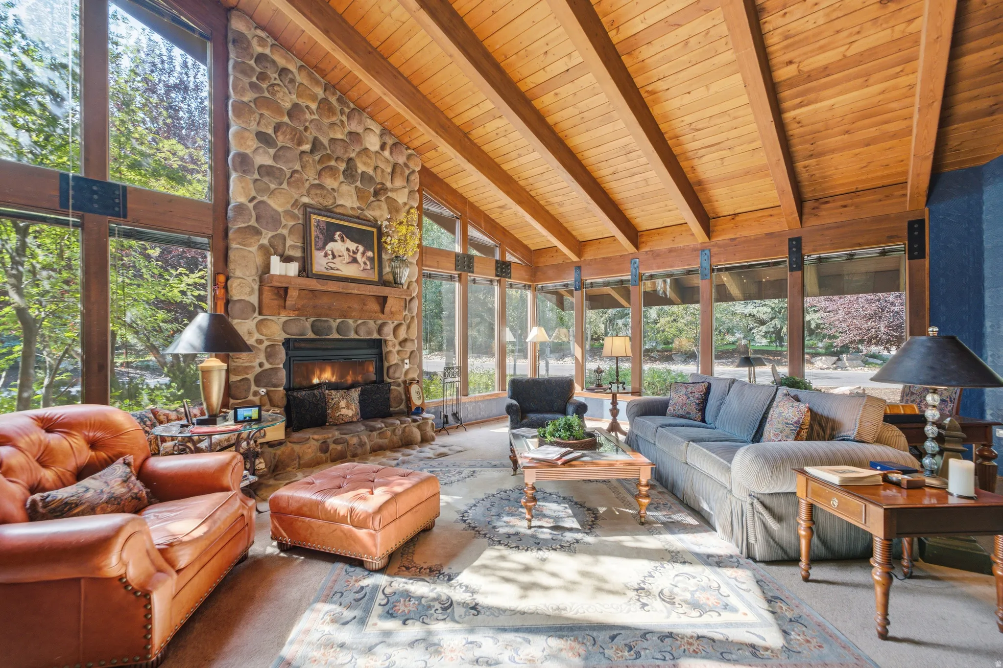 Soaring wood-beam ceiling with expansive glass walls flooding the living space with natural light