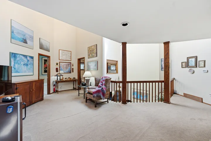 2nd floor living room  - Vaulted ceilings, wood-finish railing with vertical balusters, recessed lighting, and wall-to-wall carpeting