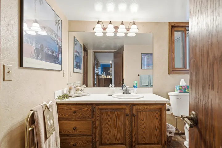Warm wood-finish vanity with ample storage drawers and cabinet, integrated sink, and extended countertop