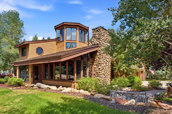 Cedar siding exterior with a prominent stone chimney