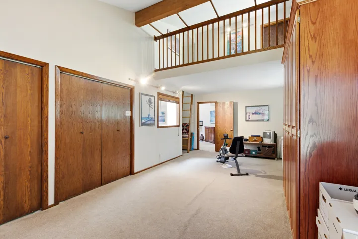 Bedroom 3 eith a loft - Carpeted flooring with wood-finish doors and a wood-finish railing on the upper level