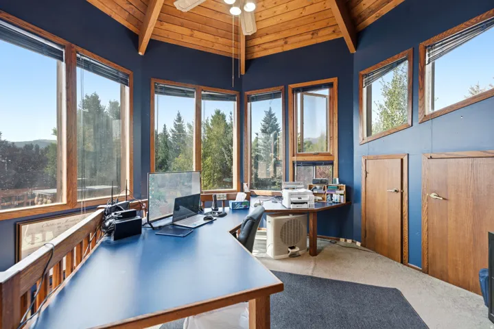 Crows Nest - Vaulted wood-paneled ceiling with exposed beams, multiple windows with wood frames, wood doors, and mixed carpet flooring