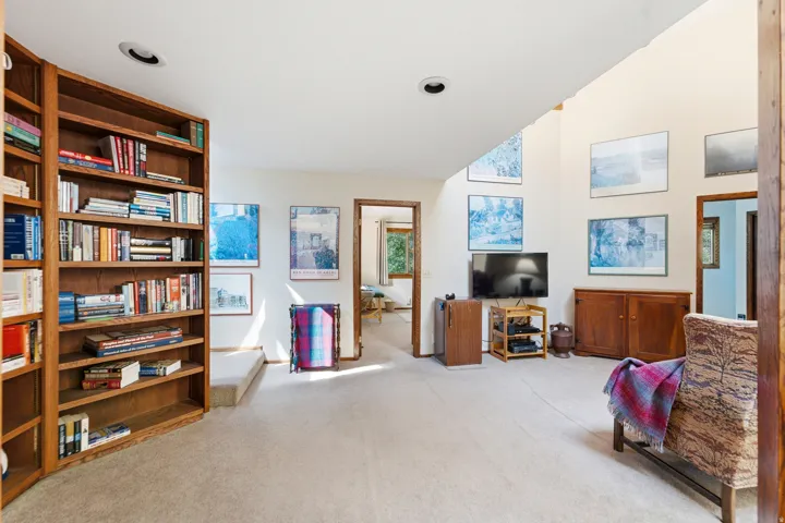 2nd floor living room - Built-in wood shelving, vaulted ceiling, recessed lighting, and multiple wall openings