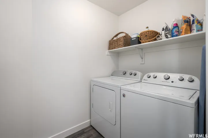 Dedicated laundry area featuring a built-in white shelf and wood-finish flooring