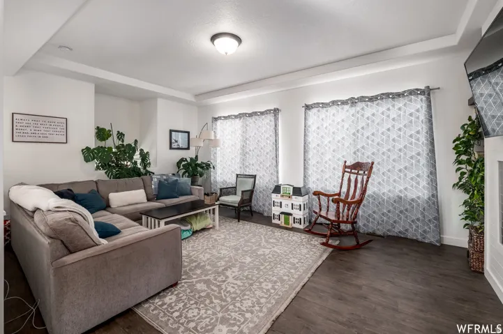 Tray ceiling, recessed lighting, wood-finish flooring, white walls, and bright windows
