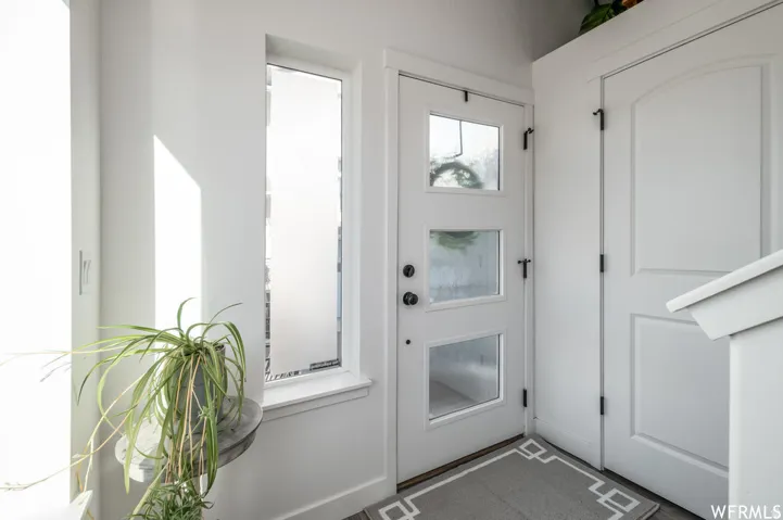 White entry door with three glass inserts and black hardware
