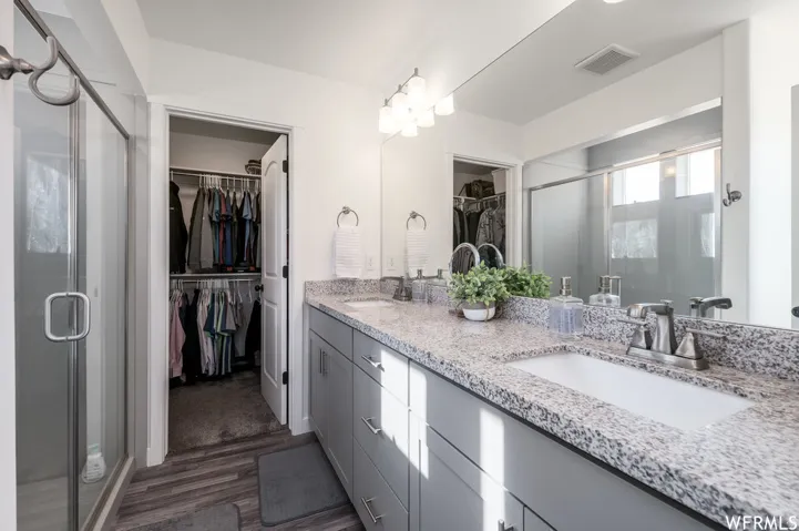 Dual sink vanity with granite-style countertop, undermount sinks, and chrome faucets