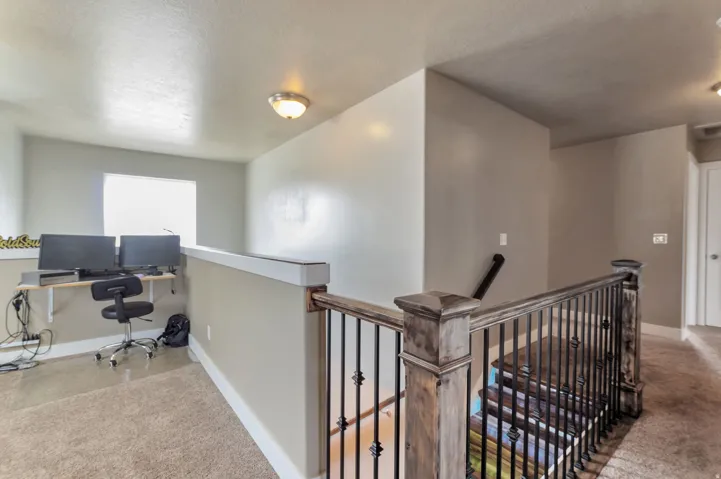 L-shaped landing with neutral carpeting and a window