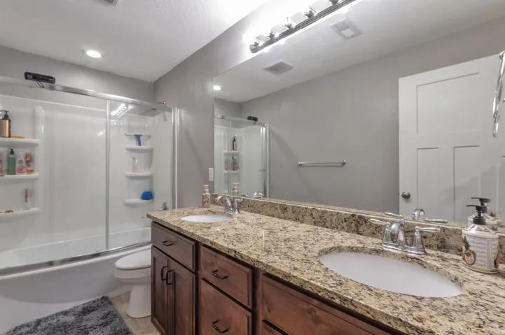 Double vanity with granite-style countertop, dual undermount sinks, and chrome fixtures