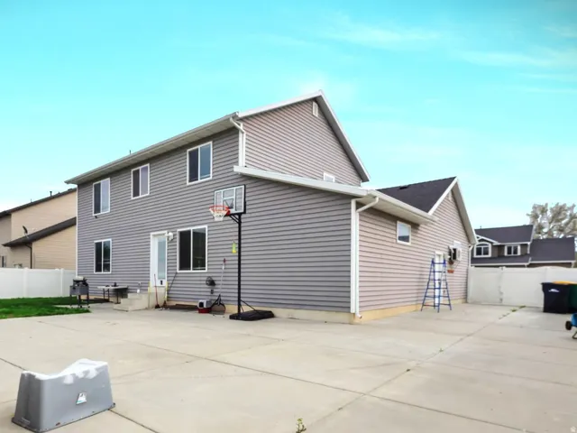 Expansive concrete driveway and patio area providing ample space for vehicles and outdoor entertaining