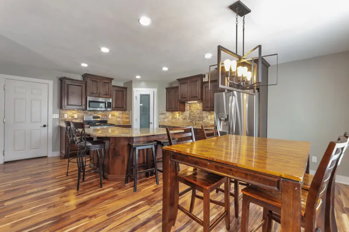Spacious kitchen featuring wood-finish flooring, dark wood cabinetry, and stainless steel appliances