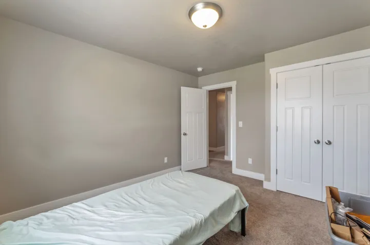 Spacious bedroom featuring neutral wall finishes, carpeted flooring, double closets with six-panel doors, and recessed lighting