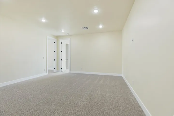 Recessed lighting, light-toned carpeting, neutral wall paint, white trim, and interior French doors