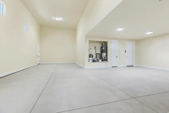 Spacious garage with polished concrete flooring, recessed ceiling lighting, and built-in storage cabinetry