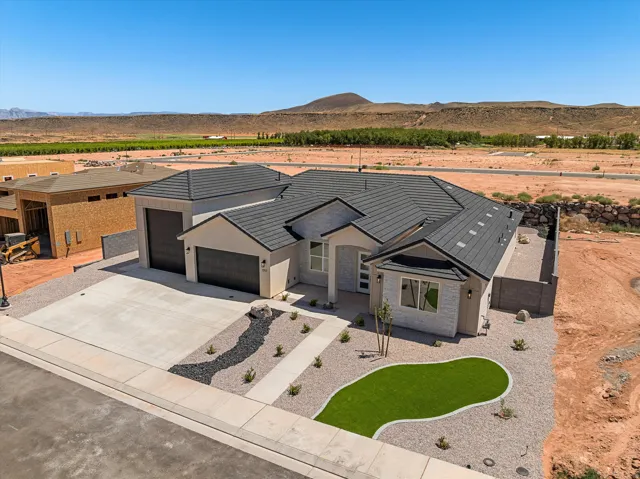 Modern stucco and stone exterior with a dark tile roof