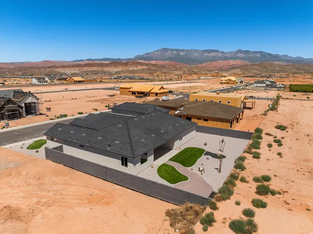 Modern residence with a striking black metal roof and clean-lined architectural design, situated on expansive desert grounds