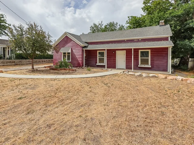 Red-sided exterior with a covered front porch and white trim