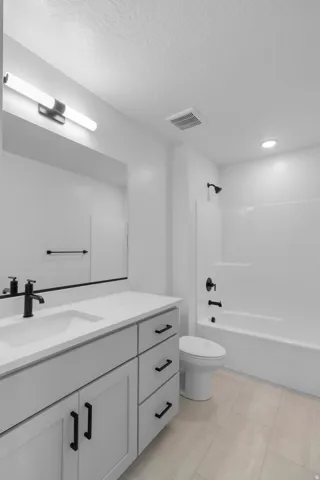 Modern bathroom featuring a white vanity with multiple storage drawers and matte black hardware, quartz countertop, and a matte black wall-mounted faucet