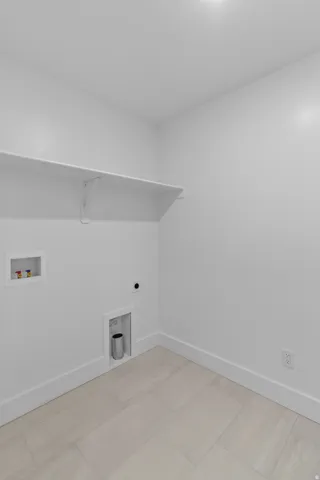 Bright utility room featuring light wood-finish flooring, white painted walls, and recessed ceiling lighting