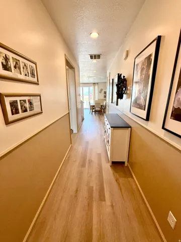 Wood-finish flooring throughout, recessed ceiling lighting, and a chair rail molding