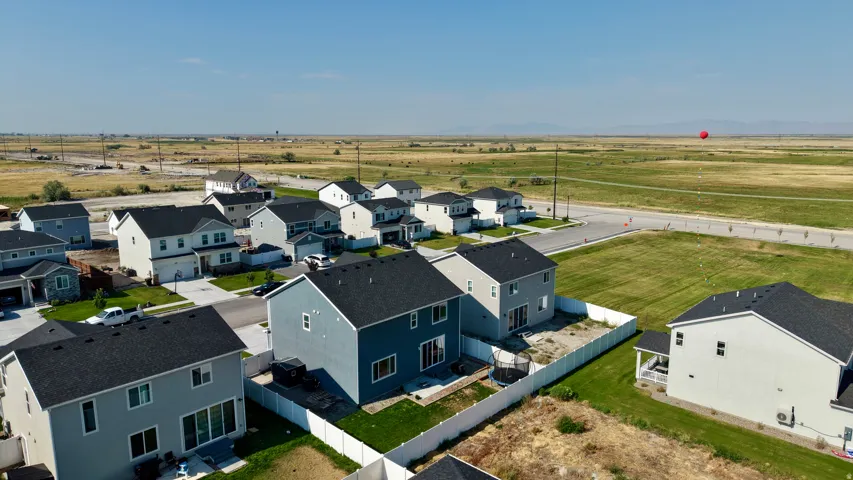 Aerial view of a new construction residential community featuring contemporary homes with modern architectural styling, dark asphalt roofing, and clean landscaping
