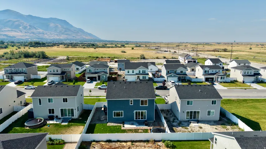 Modern residential community featuring contemporary homes with clean architectural lines, dark asphalt roofing, and manicured lawns