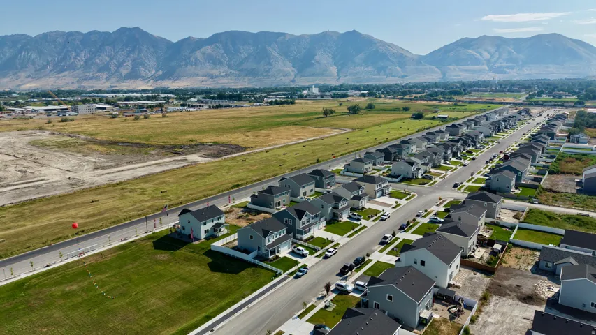 Newly constructed residential community featuring modern single-family homes with clean architectural lines, manicured lawns, and tree-lined streets