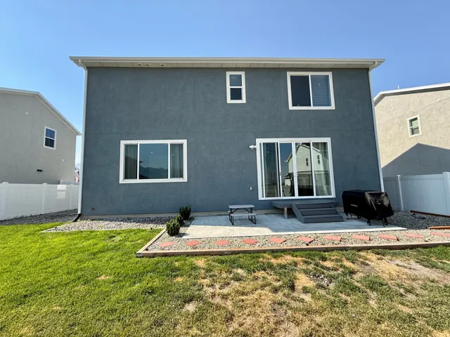 Modern two-story residence featuring a freshly finished exterior in slate blue with crisp white trim and multi-pane windows