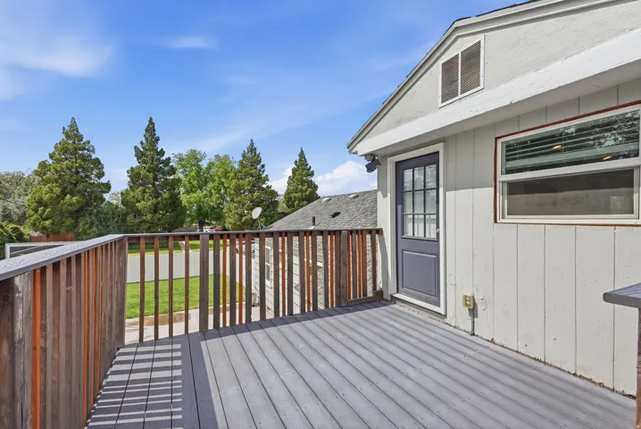 Upper-level deck featuring composite decking, wood railings, and direct exterior access