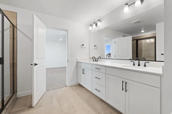 Dual vanity with white cabinetry, matte black hardware, and countertop